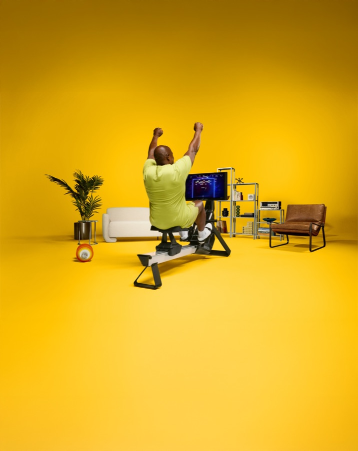 Person rowing the Aviron Strong Rower at home in a bright living space